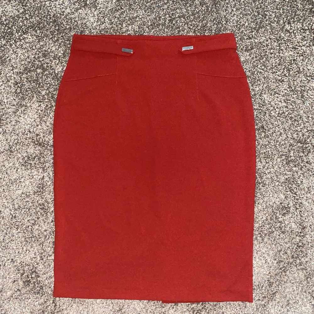 Orange stretchy mid length skirt with slit and faux front buckles for style.